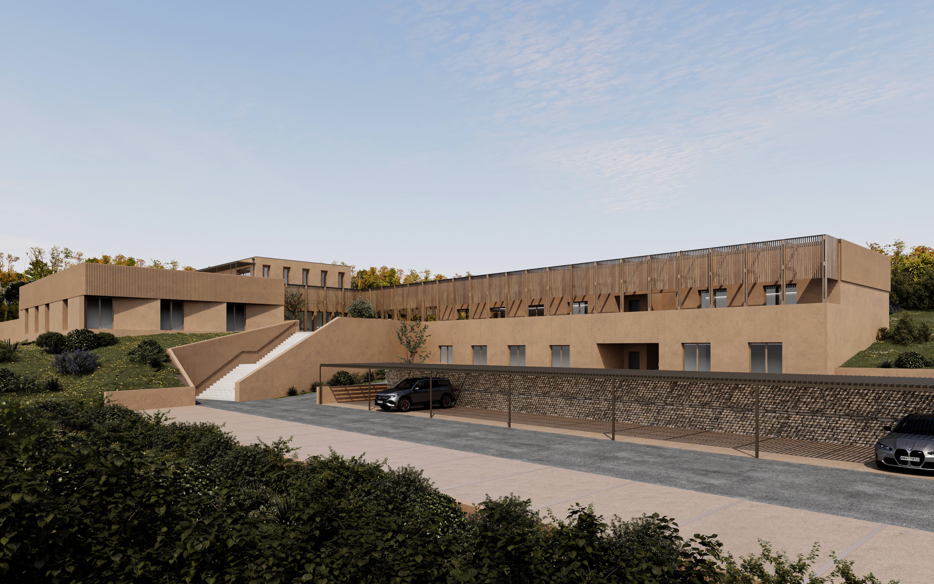 Vue d'ensemble du bâtiment en pisé intégré à la colline
